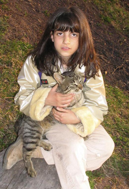 In the sentence, "the girl held her cat," the word "her" is a possessive adjective because it describes possession of the noun, "cat."